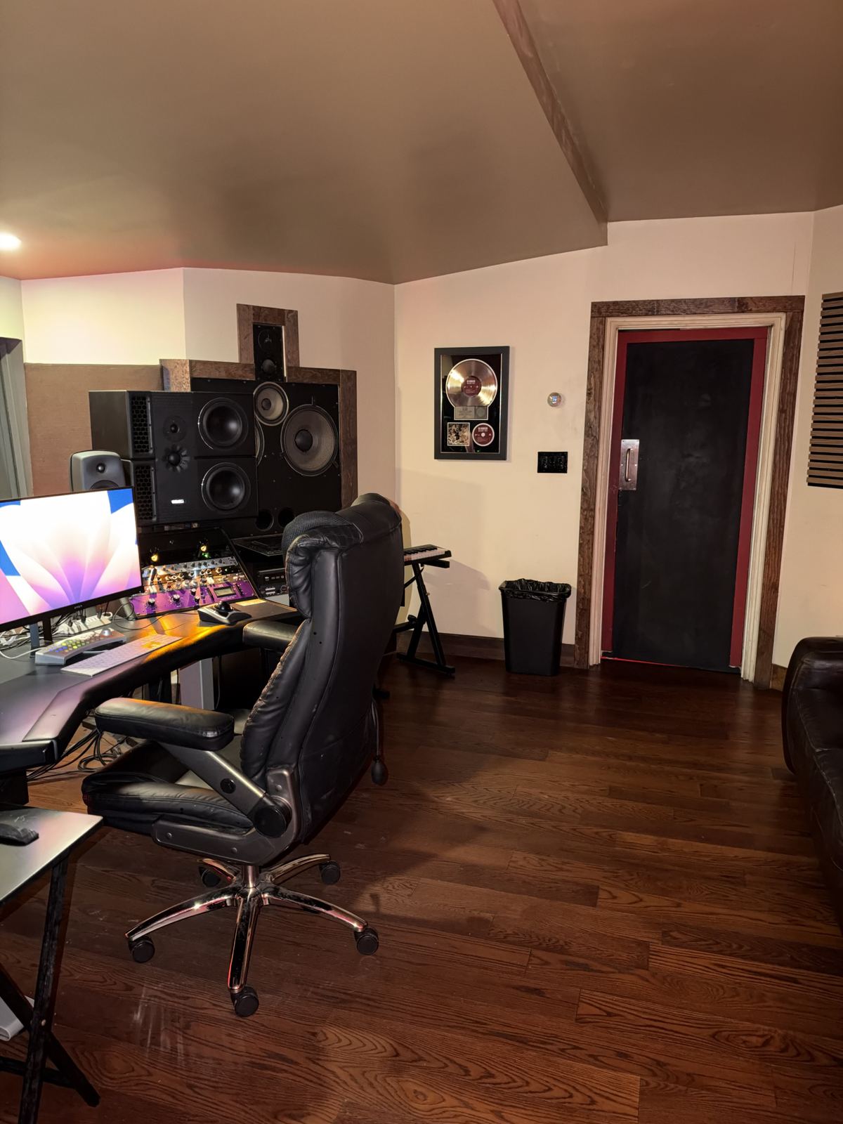 Room A from the side — chair, monitors, booth door